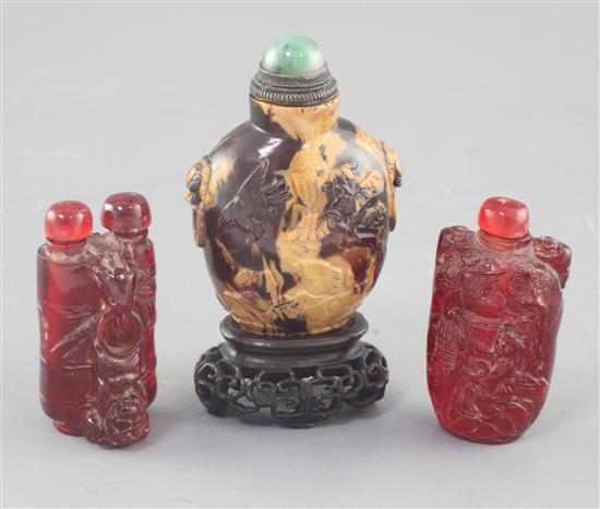 A Chinese amber snuff bottle and two cherry amber snuff bottles, 19th / early 20th century, 6.5cm incl. stopper (3)
